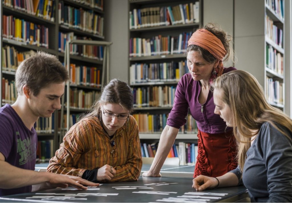 Teacher helping students in library