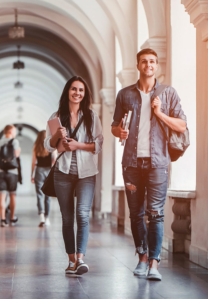 students walking down university campus hall